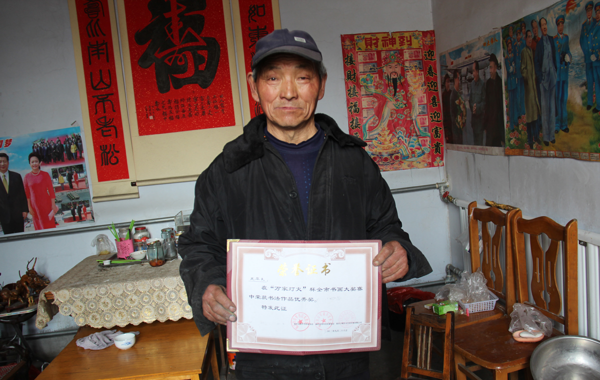 七旬環衛工自學33年 掃地之余街頭秀書法[組圖]