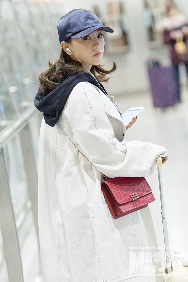 楊蓉巴黎看秀歸來(lái) 黑色帽衫搭配白色風(fēng)衣紅包搶眼